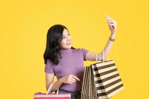 Fashion Shopping Girl Portrait on yellow background photo