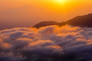 pico dorado de la montaña del amanecer con mar de nubes. perfecto para el fondo de la naturaleza y el papel tapiz. foto profesional