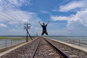 Adult man Walking on RailRoad While Travel on Summer Vacation photo