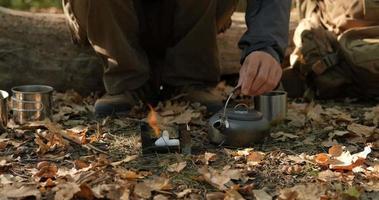 Close up of solid fuel stove with water kettle on fire, tea or coffee prepearing outdoors video