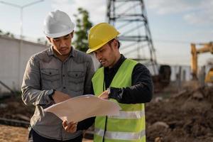 Engineers men working on building site. Construction manager and engineer meeting and discussion about project in construction site. photo