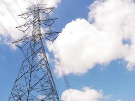 High voltage pylon overlooking the white sky and clouds photo