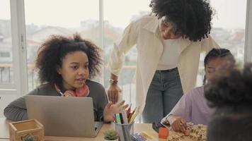 klaslokaal met diverse leerlingen van gelukkig Afro-Amerikaanse studenten en leraar die samen activiteiten doen. de leraar geeft les, begeleidt en praat met de kinderen in divers. video