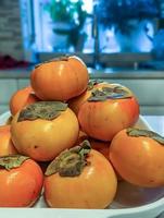 fresh persimmons on a kitchen table photo