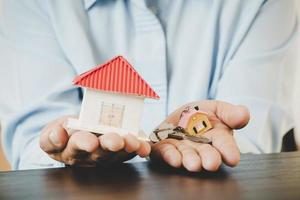 Real estate agent with house model and keys photo