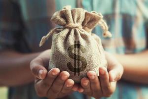 woman hand holding money bag. concept saving finance and accounting photo