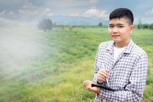 rural boy using tablet Keeping records of working in agricultural fields photo