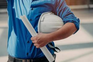 Close Up Engineering holding Safety helmet and a blueprint. photo