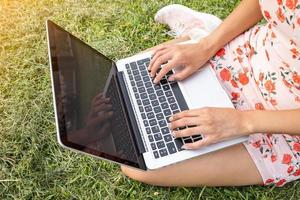 girl with a laptop on green grass photo