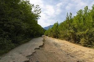 After an earthquake and a strong storm, the remains of an asphalt road in the mountains. Closed road. Destroyed asphalt road. Broken asphalt, crack and landslides. photo