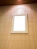 marco de fotos vacío con luz y pared de madera