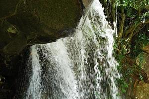 el agua del arroyo fluye a través de las losas de piedra. foto