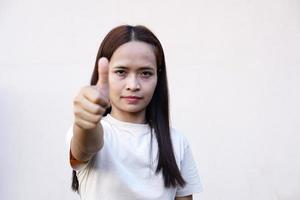 Asian women hold their thumbs as a great sign. photo