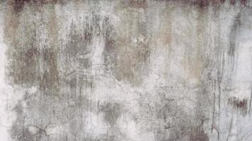 The old cement wall was weathered, the surface was scratched, the surface was scratched and damaged. For a mysterious retro-conservative background. photo