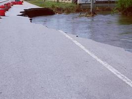 Natural flood disasters have damaged road surfaces and damaged road surfaces. cause traffic congestion photo