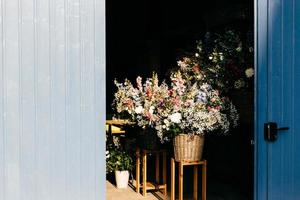 Beautiful flowers with pleasant smell in wooden backet. Bouquet of beautiful flowers with nice odour standing on chair in wooden backet. Blooming flowers photo