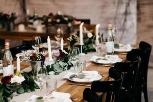 Festive table served for wedding or birthday. Beautiful cutlery, candles, luxurious chairs and table. Elegant dinner table. Party and celebration concept. Beautifully organized event. photo