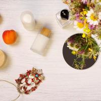 Cosmetic bottles, fruit flowers and mirror on table, lifestyle staging photo