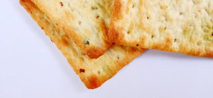 Sugarless and vegetable healthy cracker biscuit slices on the gray white studio background. Food background design. Suitable for promotion of food and beverage industry and company, food advertising. photo