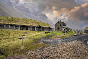 casas tradicionales en el campo de hierba en el pueblo vikingo contra el cielo al atardecer