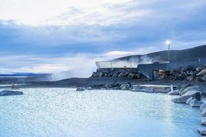 Natural hot spring in geothermal spa against cloudy sky during winter photo