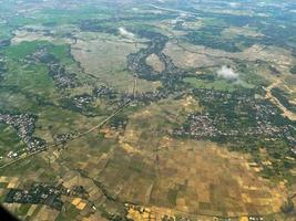 The aerial landscape shows a green view of the city. Streets, rice fields, and village houses. photo