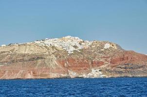 Oia town on Santorini island, Greece. Traditional and famous houses and churches with blue domes over the Caldera, Aegean sea photo