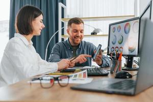 hablando y creando contenido. dos diseñadores trabajando juntos en la oficina foto