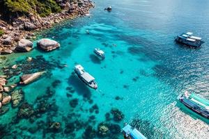 Boats and crystal clear waters at the bay dive site in Koh Tao,diving tour boat photo