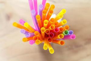 multi colored drinking straws on wooden table photo