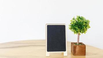 Blank black frame mock up picture frame  mini  tree in pot on wooden table photo