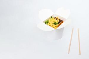 Rice wok in box and wooden chopsticks isolated on white background, Asian food delivery, copy space photo