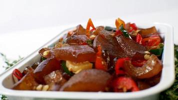 Stir-fried beef skin served in an aluminum place with typical Indonesian food on a white background photo