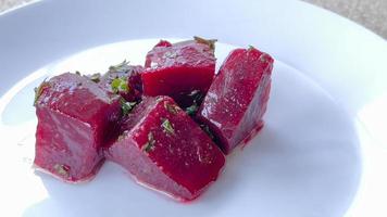 A piece of beetroots sliced with salad on white dish. photo