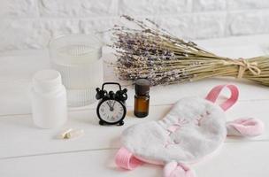 melatonin capsules and lavender essential oil on a table photo