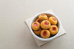 Thumb print cookies filled with strawberry jam and grated cheese.  Familiar during the month of Ramadan and Eid Fitri. photo