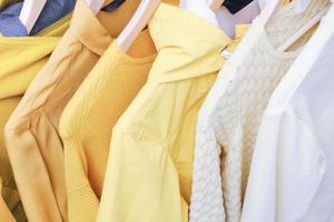ropa femenina en color amarillo en percha. limpieza de primavera. foto