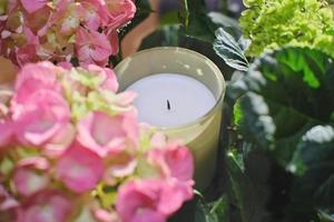 perfumed candle and flowers. home fragrances for cozy atmosphere. photo