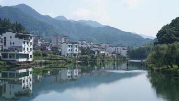 The beautiful Chinese countryside village view with  the old traditional buildings surrounded by the natural environment photo