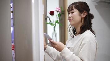 A woman who operates a smartphone and takes out ingredients from the refrigerator video