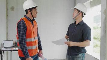 twee zelfverzekerde ingenieurs die blauwdruk bespreken terwijl ze op de bouwplaats staan video