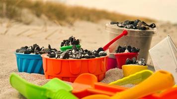 juguetes coloridos en la playa para que los niños caven. la arena se usa para construir castillos y formas foto