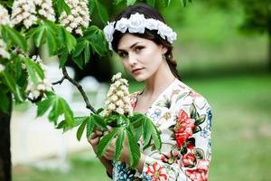 Woman's portrait with a hair moving in the wind.  portrait of young beautiful Russian brunette girl at summer green park. European white woman in dress. photo