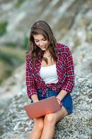 Office outdoors. Beautiful girl works on a laptop in the open air. woman freelancer. Freelance worker concept. photo