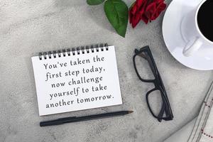 Motivational and inspirational quote on notebook on white marble table. photo