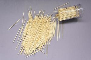 Pile of round wooden toothpicks on purple background. Copy space. photo