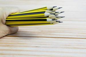 Wooden 2b pencils lying on red note book on wooden table. Copy space. photo