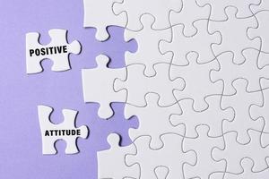 Positive attitude word on white jigsaw puzzle with some missing pieces. photo