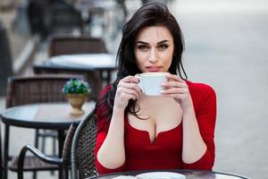 joven mujer con estilo tomando café en una calle de la ciudad. chica hipster con estilo tomando café en la calle. retrato de moda al aire libre de una joven hermosa bebiendo café. foto