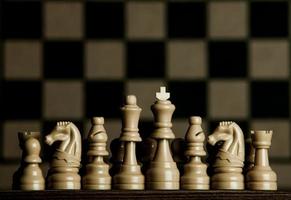tablero de ajedrez con piezas de ajedrez. ajedrez en el fondo oscuro. concepto de éxito empresarial. estrategia. mate. foto